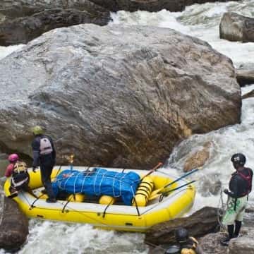 a group of people on a raft in a rocky area
